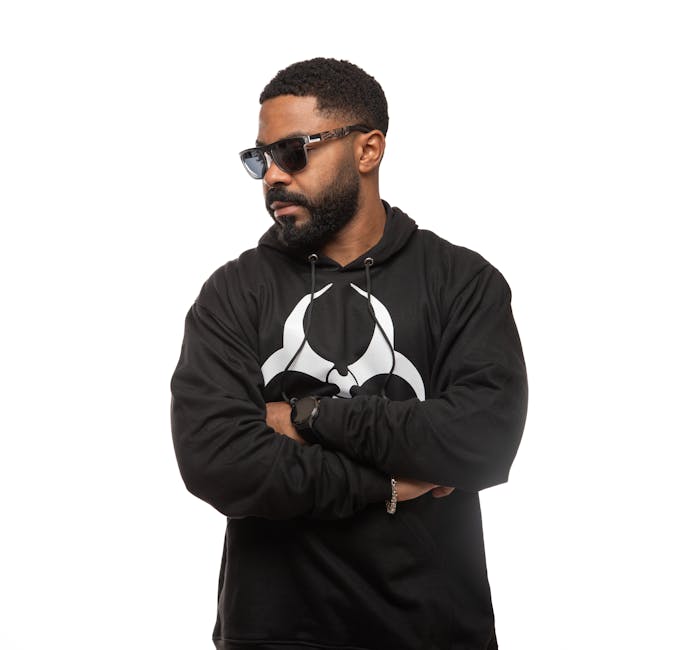 Man wearing a stylish black hoodie with a biohazard symbol, exuding confidence and style.