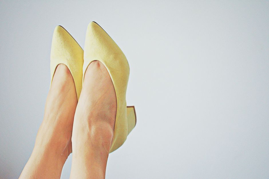 Close-up of chic yellow high heels against a minimalistic backdrop, perfect for fashion concepts.