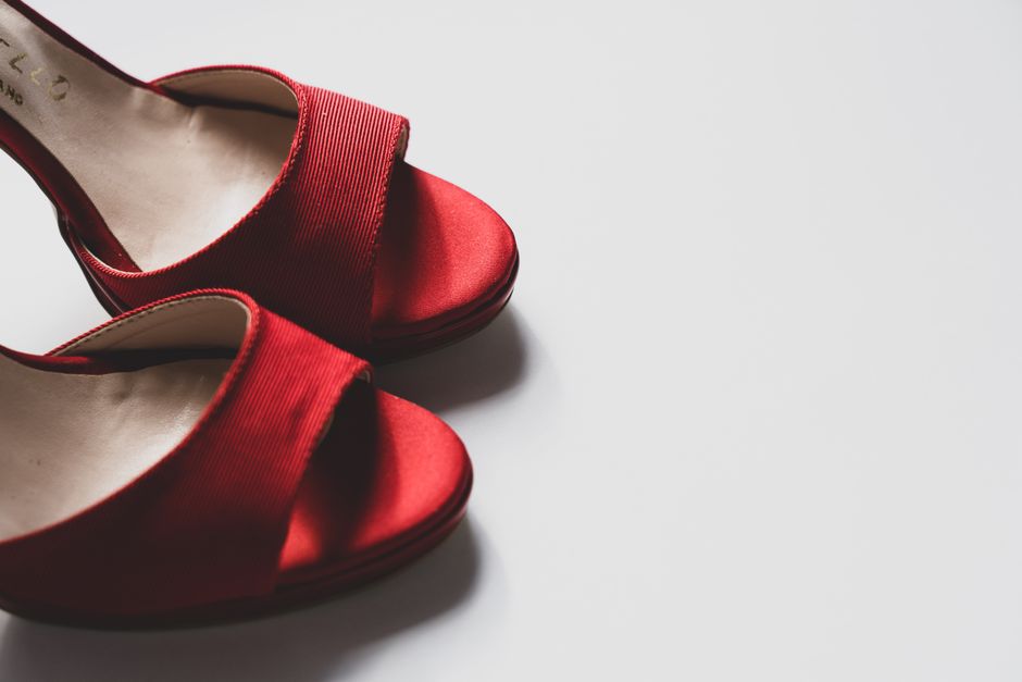 Stylish red high heel shoes on a clean white background, perfect for fashion and elegance themes.