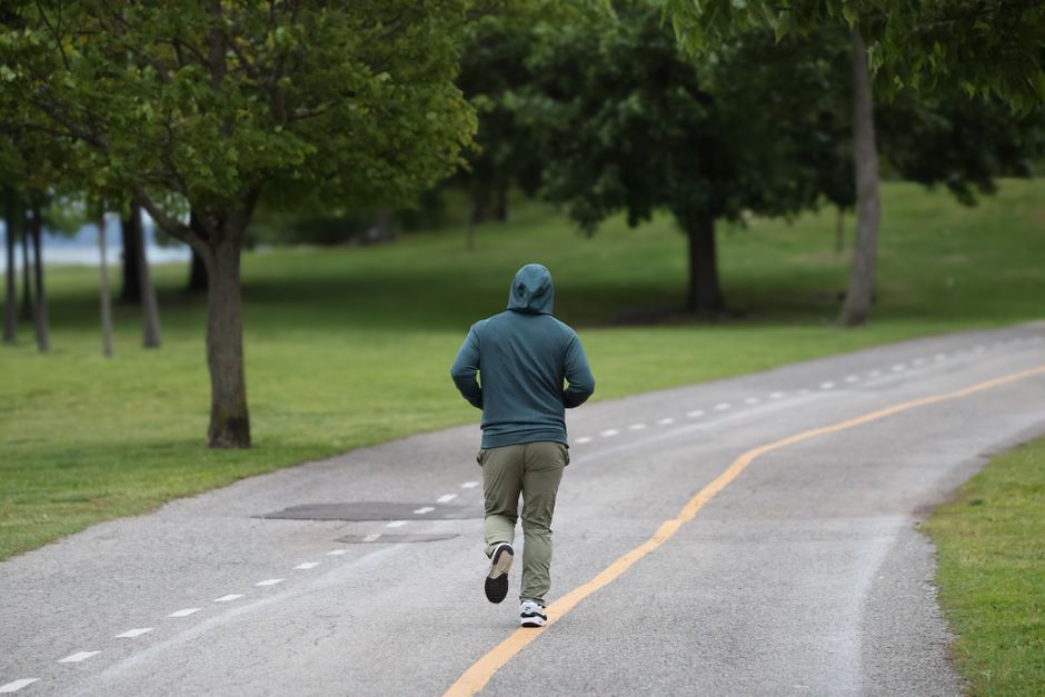 A person jogging on a trail in Stamford, Connecticut park during a spring morning.