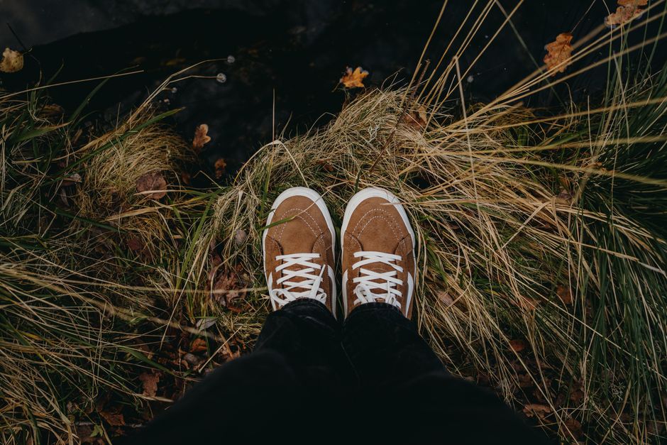 Close-up of shoes on grass in Castro Laboreiro, Portugal, showcasing outdoor style.