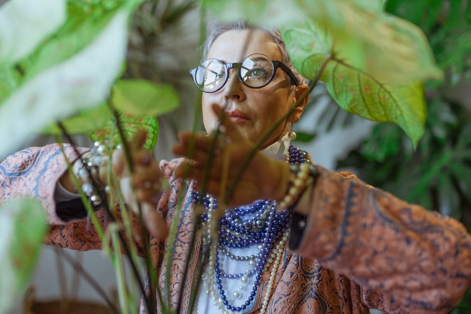 Stylish senior woman with glasses and chic accessories tending to indoor plants.