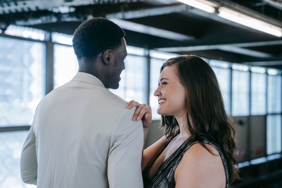 Candid portrait of a smiling interracial couple embracing indoors.