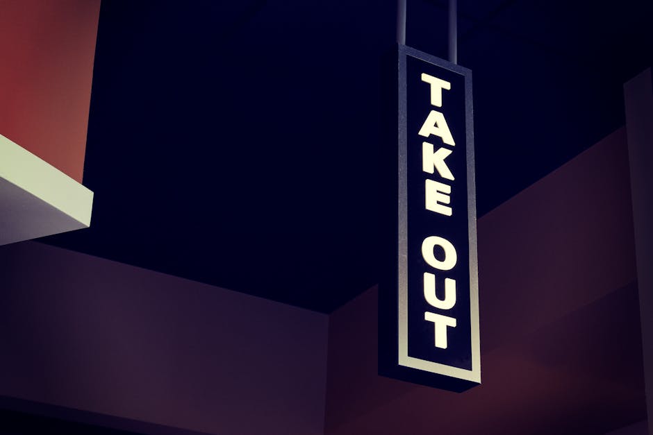 Vertical take out sign hanging indoors in a modern restaurant setting.