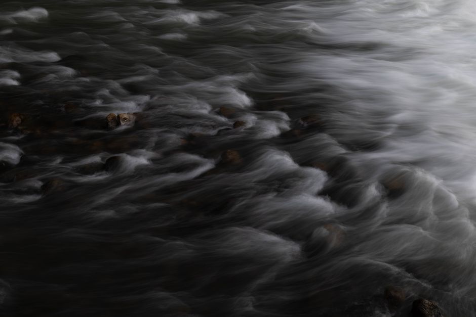 Captivating long exposure photo of water flowing over rocks, creating a soft and dreamy effect.