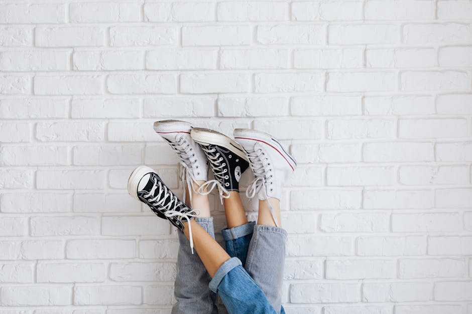 Fashion-forward sneakers displayed upside down against a white brick wall for stylish urban appeal.